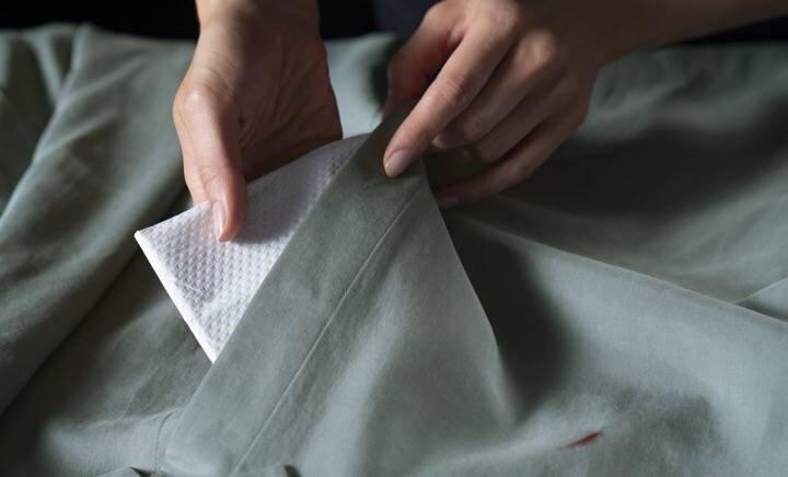 τοποθετώντας πετσέτα κάτω από το λερωμένο ύφασμα