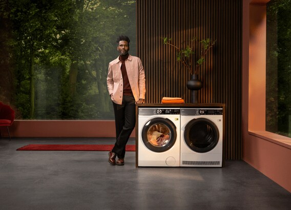 Man standing next to a washing machine unit.